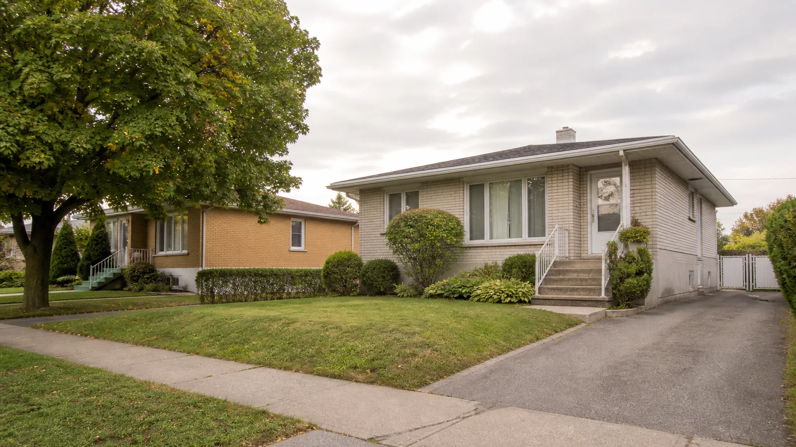Bungalow en brique dans une rue calme et arborée de Laval.