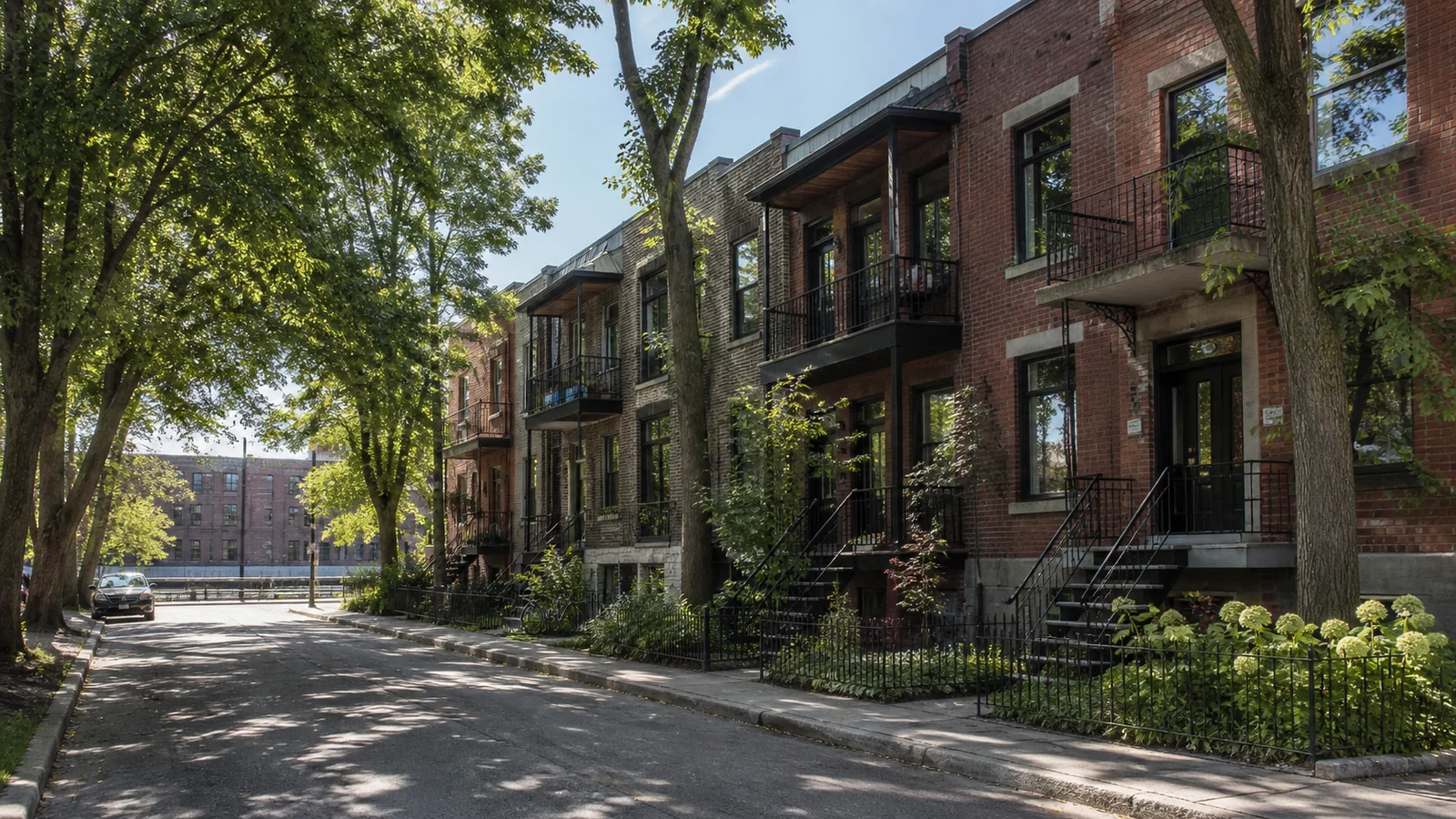 Rue arborée du Sud-Ouest bordée de duplex et triplex en brique avec escaliers extérieurs.