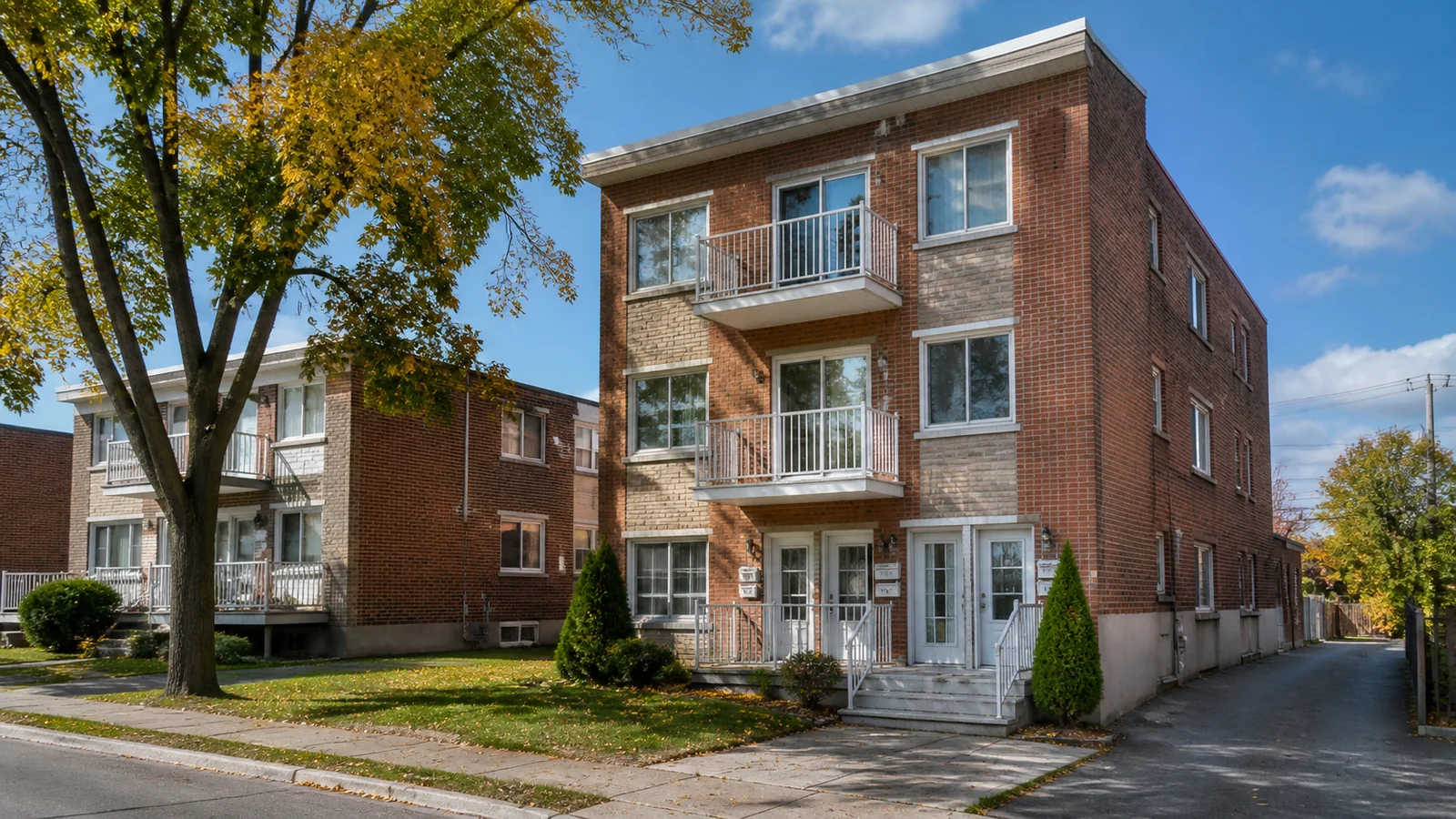Triplex en brique avec balcons dans une rue résidentielle du Longueuil.