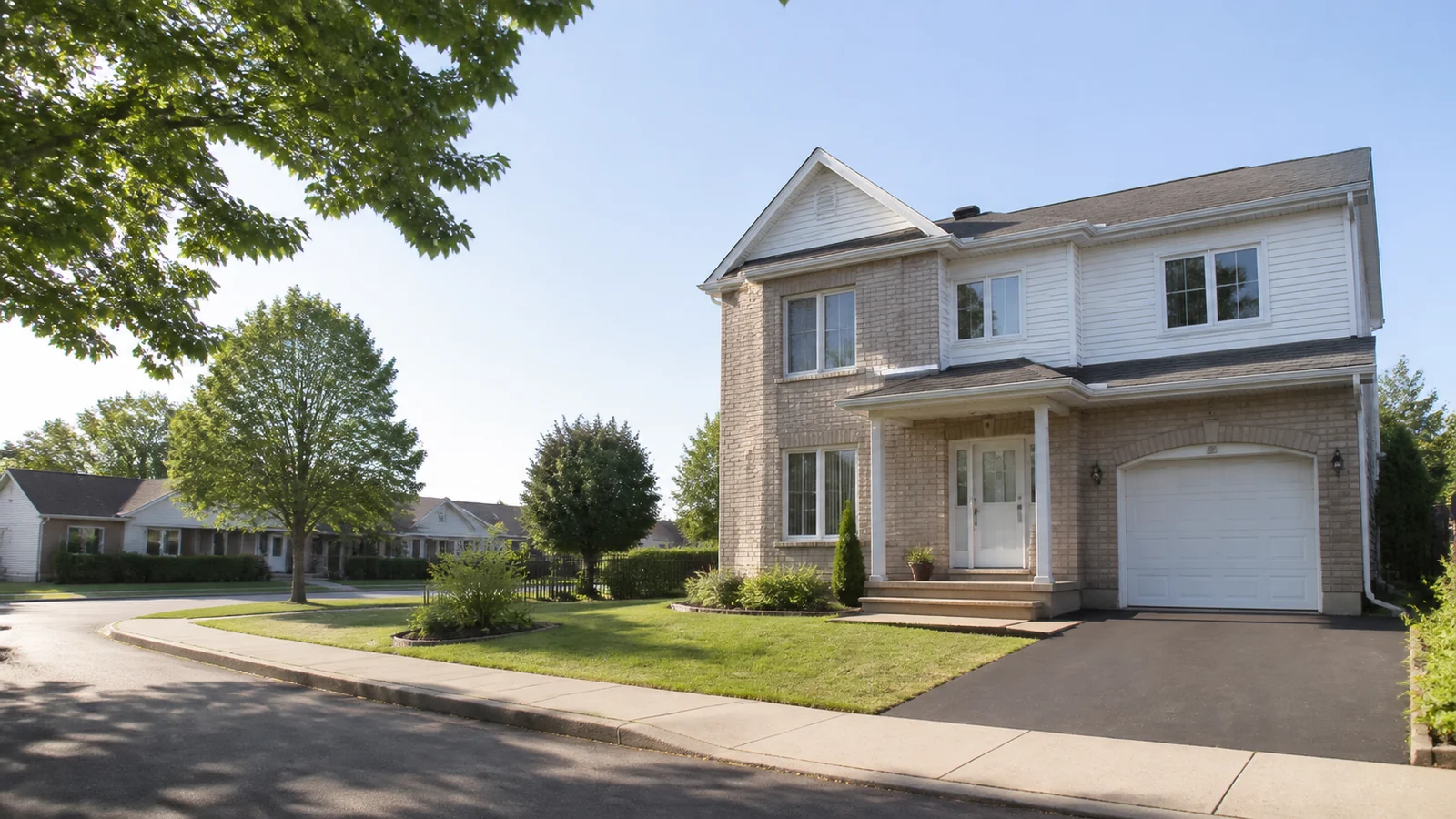 Maison de ville en brique avec jardin dans une rue arborée du Longueuil.