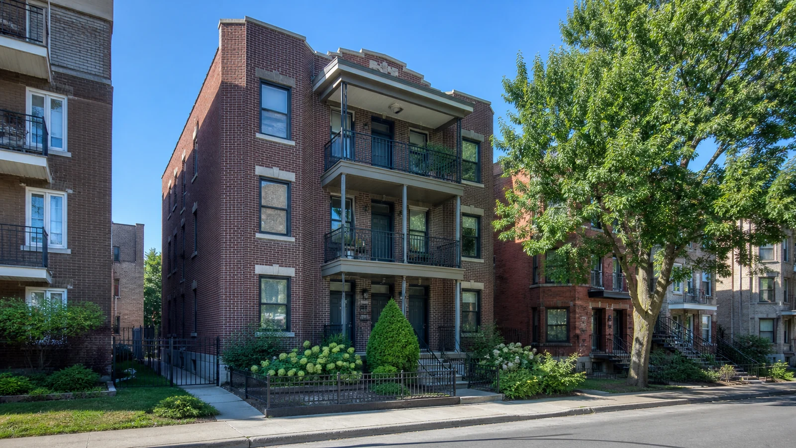 Triplex en brique avec balcons dans une rue résidentielle de Villeray–Saint-Michel–Parc-Extension.